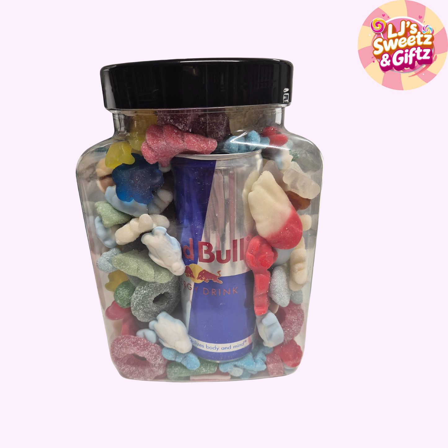 Jar of colorful gummy candies with a small bottle of Red Bull inside, on a light pink background.