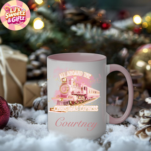 Pink mug with Christmas train design and 'LJ's Sweetz & Giftz' logo in a festive setting.