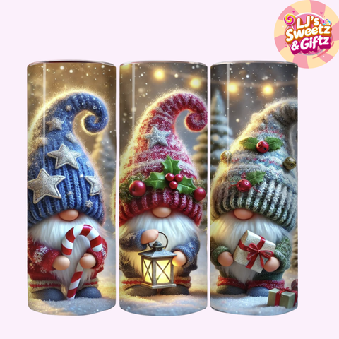 Three decorative gnomes with winter-themed accessories in cylindrical packaging, featuring a brand logo in the corner.