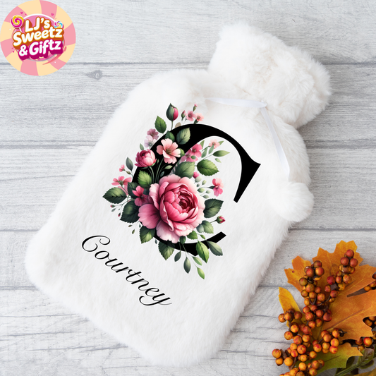 White Hot water bottle with floral design and 'Courtney' text on a wooden surface, featuring the brand 'LJ's Sweetz & Giftz'.