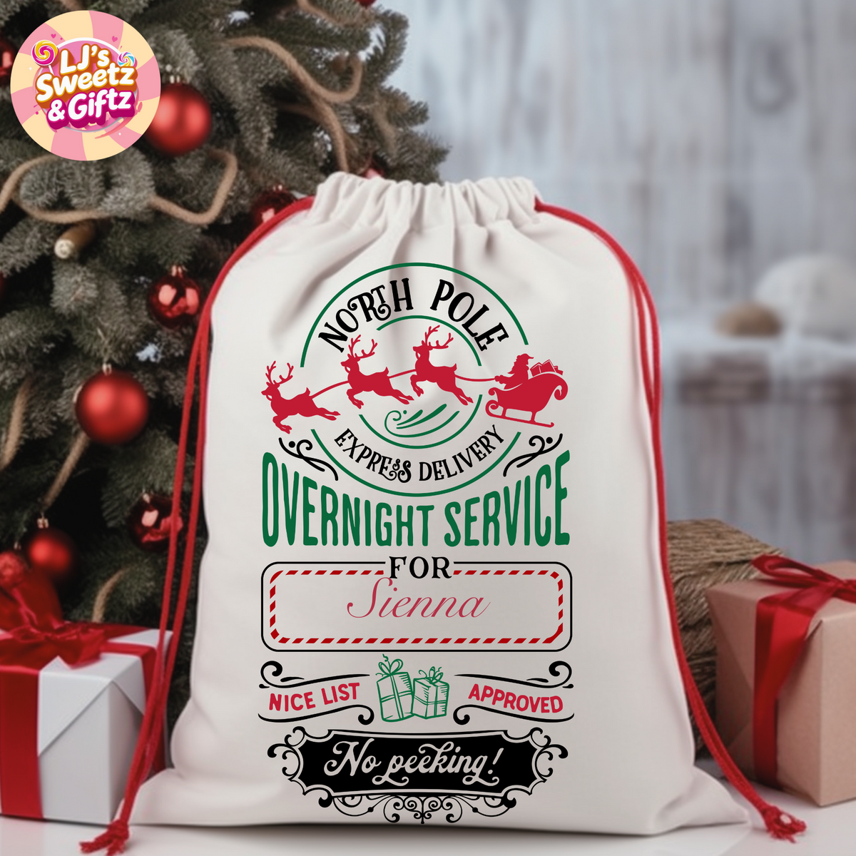 Personalized Christmas gift sack with Santa Claus design and text, placed in front of a decorated Christmas tree.