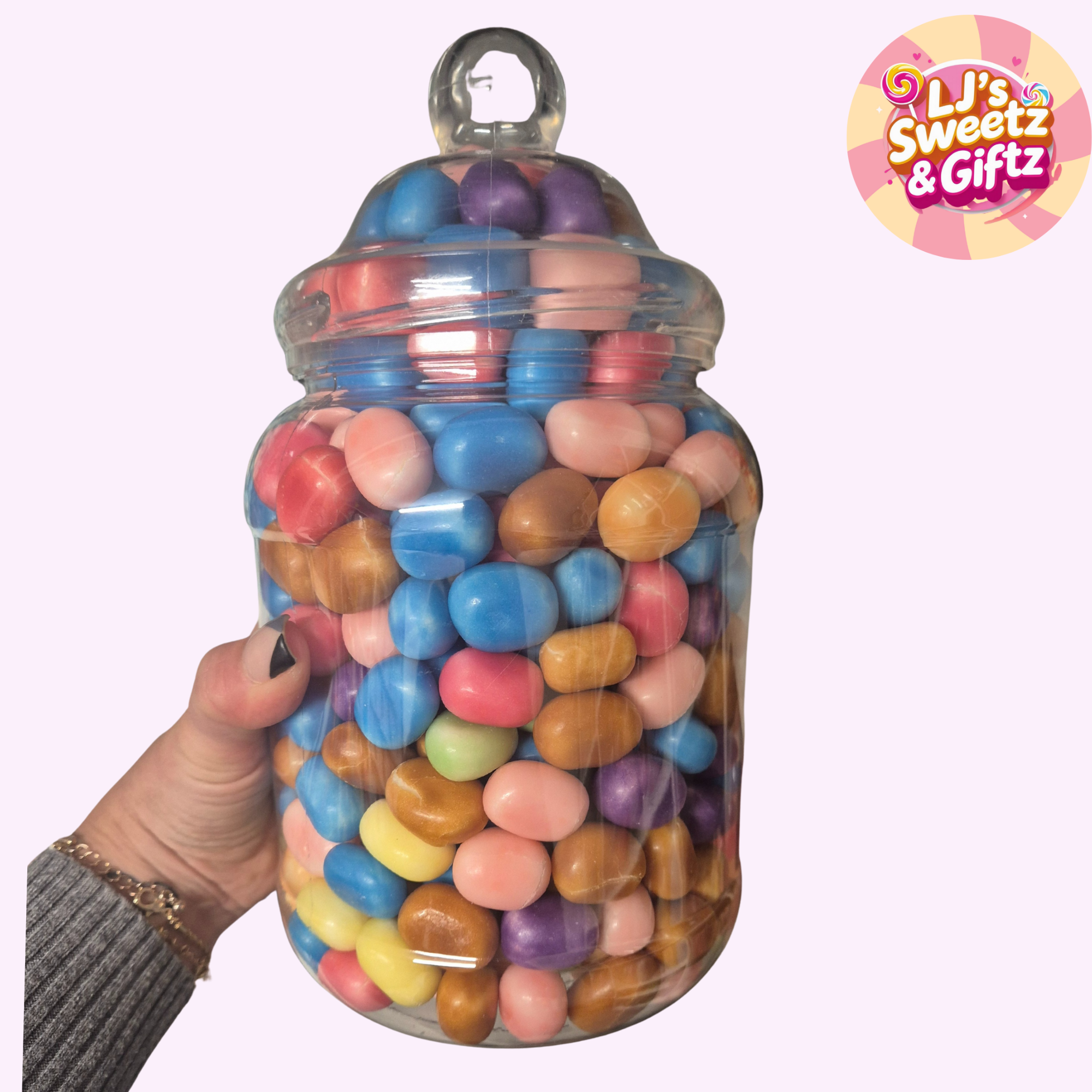 Jar of colorful candies held by a hand with 'LJ's Sweetz & Giftz' logo in the corner.