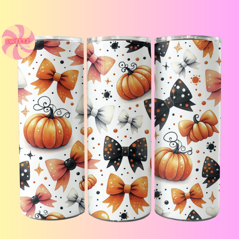 Three tumblers with Halloween-themed designs featuring pumpkins, bows, and stars on a gradient background.