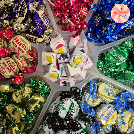 Assorted colorful candy in a tray with visible brand names.